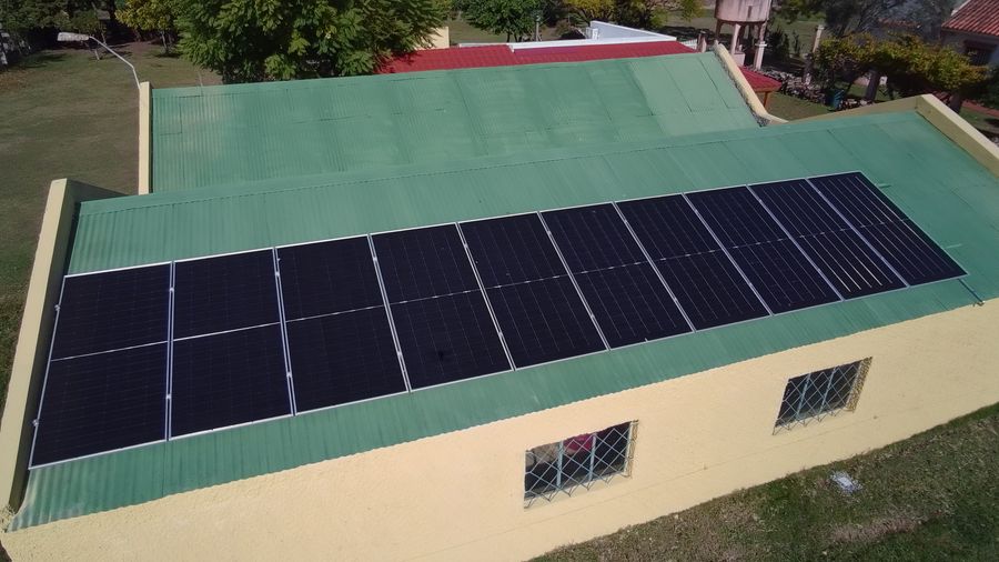 Vista aérea de un galpón rural con paneles solares en el techo