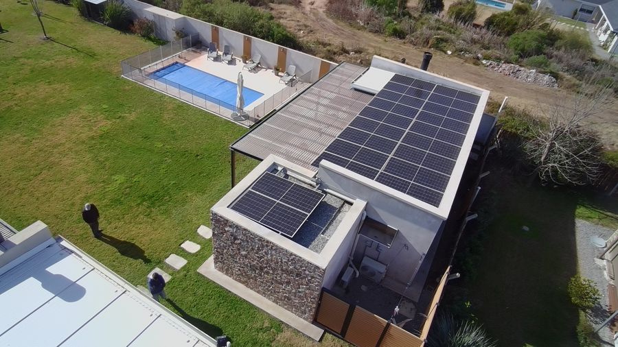 Vista aérea de una casa con piscina y paneles solares sobre la barbacoa
